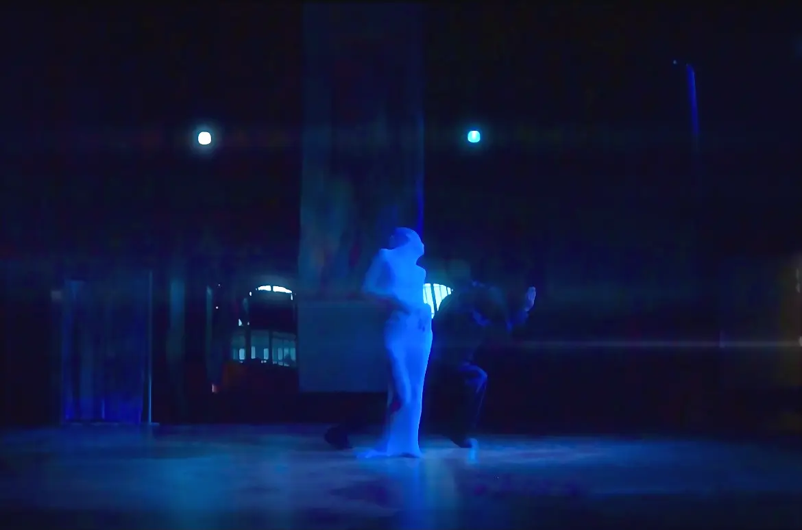Two performers in blue light on stage